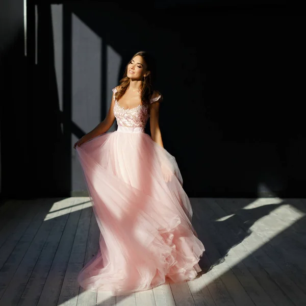 Delikatna, piękna dziewczyna w różowej sukience uśmiecha się i tańczy w — Zdjęcie stockowe