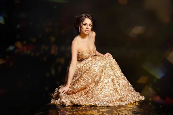 Vacker sexig och glamorösa brunett flicka i en guld klänning. Blac — Stockfoto