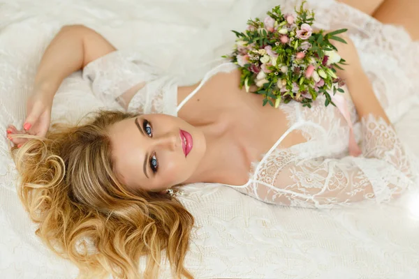 Portret van een blond meisje met blauwe ogen met bloemen liggen op th — Stockfoto