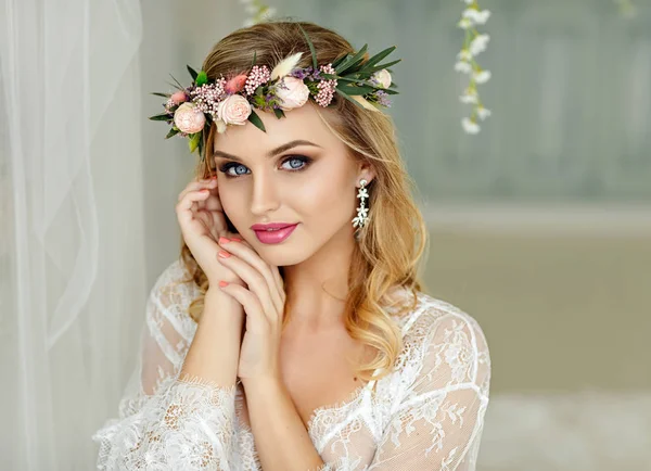 Porträtt av en blond tjej med blå ögon med en krans av blomma — Stockfoto