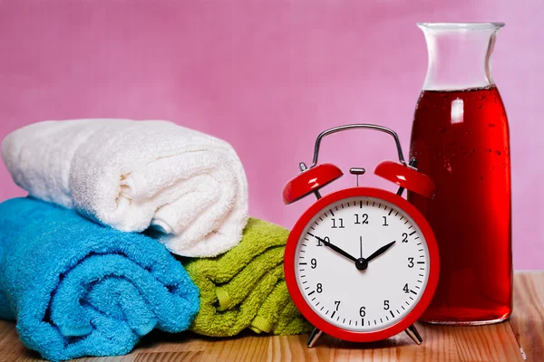 Bunch of towels, vintage clock and carafe of wine.