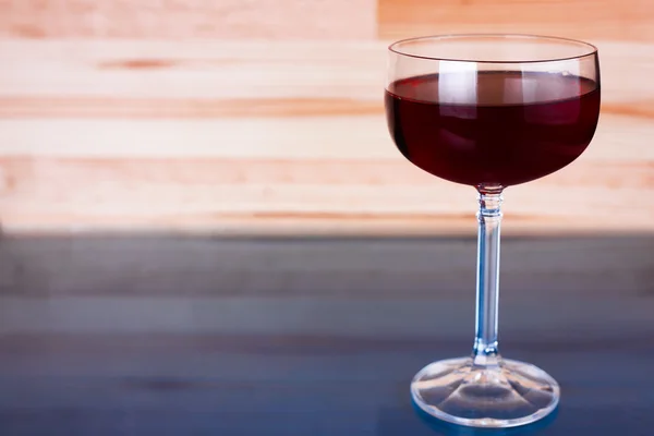Glass of wine on natural and blue wooden background.