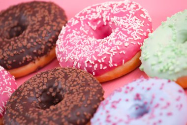 Pembe bir arka plan üzerinde renkli tatlı lezzetli börekler.  