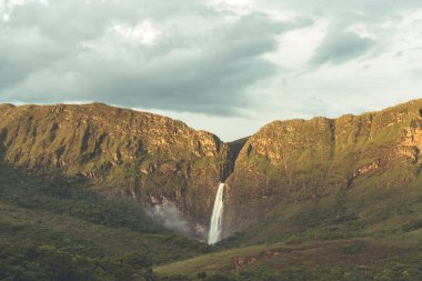 Gün batımında Brezilya 'da gökyüzünde bulutlarla Minas Gerais kanyonlarında inanılmaz bir şelale.