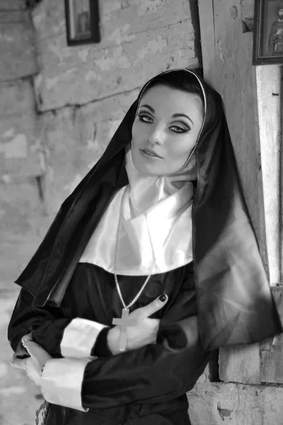 Svartvitt foto av religiösa vackra nunna. Bedjande nunna i kyrkan. Närbild händerna på nunnor som pressar mot hans bröst Bible.Religious nunna i religion koncept mot mörk bakgrund. — Stockfoto