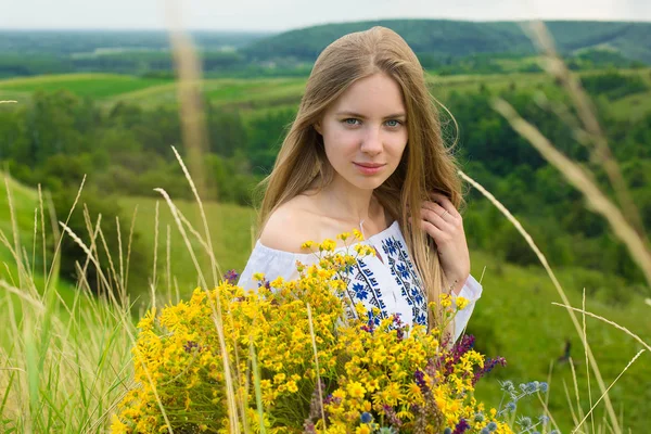 Retrato al aire libre de una hermosa mujer rubia, atractiva joven en el campo de manzanilla con flores. Joven chica hermosa en el campo en verano. Cosmos flores en las manos. Chica con ramo de flores —  Fotos de Stock
