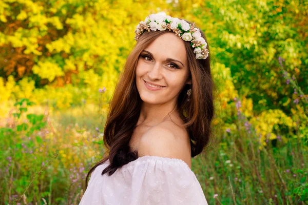 Retrato de rubia sensual con flores en la cabeza. Linda chica sonriente en primavera en el día soleado. Hermosa chica con linda sonrisa blanca con corona de flores blancas. Primer plano de chica con flores — Foto de Stock