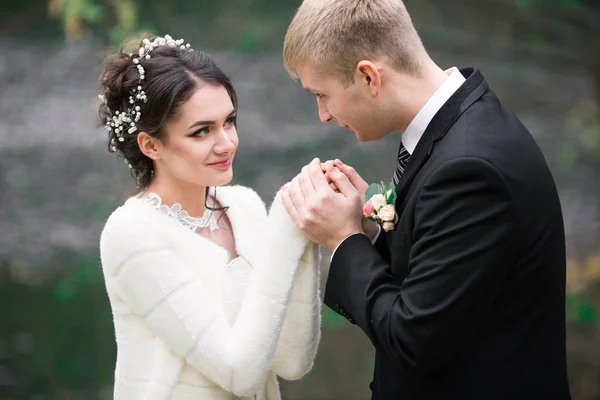 Casamento casal ao ar livre está abraçando uns aos outros. Menina modelo bonita em vestido branco. Homem de fato. Noiva de beleza com noivo. Retrato feminino e masculino. Mulher com véu de renda. Mulher bonito e cara bonito — Fotografia de Stock