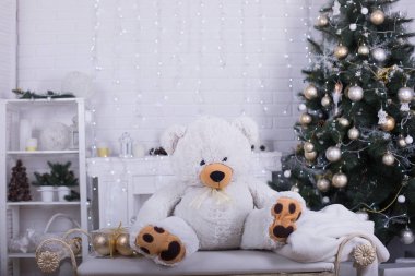 Büyük beyaz kabarık beyaz güzel Noel Studio bankta oturmuş ayıcık. Noel oda iç dekorasyonları Studio. Oyuncak ayı beyaz arka plan üzerinde klasik vintage tarzı.