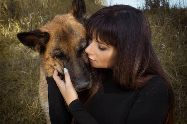 Kız ve köpek. Köpek ile küçük kız. Kız ve köpek her diğer karşılamak. Hayvanlar, köpekler için büyük gerçek aşk. Güzel kız ve onun sevimli köpek portre portre. Genç uzun siyah saçlı büyük köpek sarılma mutlu.