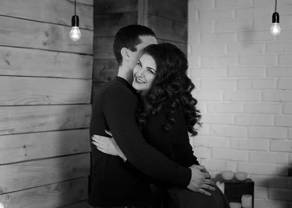 Мужчина и женщина обнимаются. Счастливая женщина обнимает своего мужа. Счастливая пара в его новой квартире. Черно-белая фотография. Концепция счастья . — стоковое фото