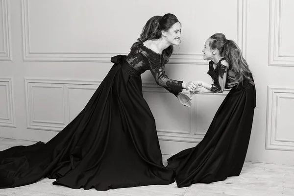 Anne ve kızı sarılma ve kameraya bakıyor. Mutlu sevgi dolu aile. Anne ve kızı güzel uzun lüks mavi elbise, makyaj saç modeli. Moda aile portait. Nesil ilişki