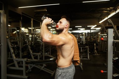 Spor salonundaki yağmurdan sonra su içen yakışıklı antrenör..