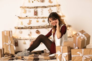 Neşeli güzel kadın Noel hediyesini beyaz arka planda açar. Yeni Yıl 2020.