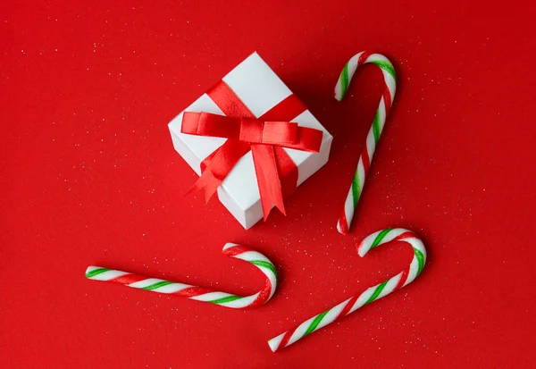 Coffret cadeau blanc avec noeud ruban rouge et bonbons de Noël — Photo