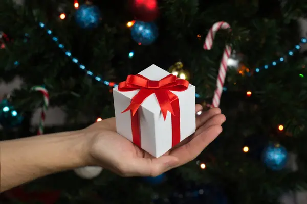 Hediye kutusu Noel ağacı yakınındaki tutan adam