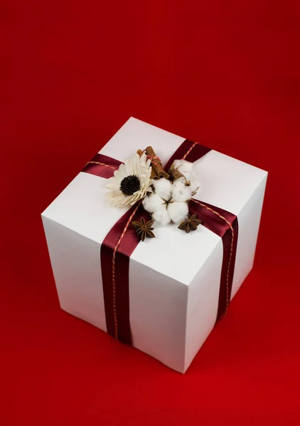 Scatola regalo con fiocco nastro rosso su sfondo rosso — Foto Stock