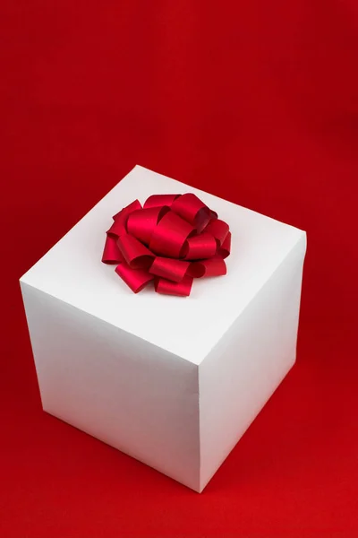 Caja de regalo con lazo de cinta roja sobre fondo rojo — Foto de Stock