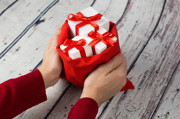 Mann hält Geschenkbox auf Holz Hintergrund — Stockfoto