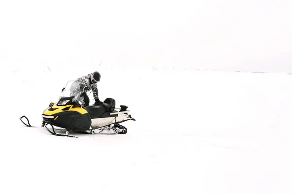スノーモービルの男。冬の休日の自然のレクリエーションの概念。冬のスポーツ. — ストック写真