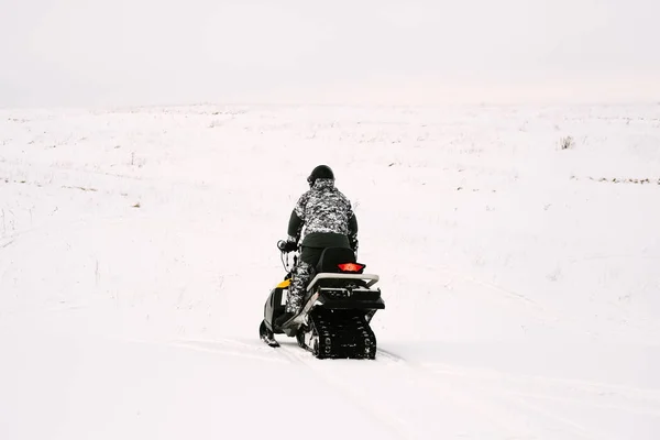 Uomo in motoslitta. Concetto ricreativo sulla natura durante le vacanze invernali. Sport invernali . — Foto Stock