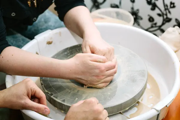 Pottery. the teacher teaches the student work on the potter's wheel — Stock Photo, Image