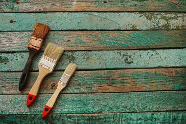 Eski fırça ve bir ahşap yüzey üzerinde iki yeni fırçalar. İş kavramı ekip çalışması, eğitim ve takım oluşturma.