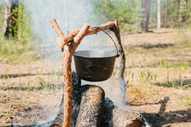 Ateşin yanında kamp. Yemek yemek bir yanıyor. Vahşi kavramı içine yolculuk.