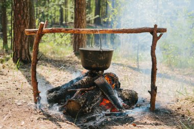 Ateşin yanında kamp. Yemek yemek bir yanıyor. Vahşi kavramı içine yolculuk.
