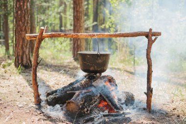 Ateşin yanında kamp. Yemek yemek bir yanıyor. Vahşi kavramı içine yolculuk.