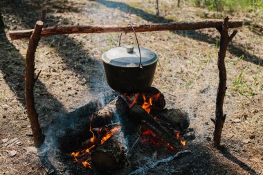 Ateşin yanında kamp. Yemek yemek bir yanıyor. Vahşi kavramı içine yolculuk.
