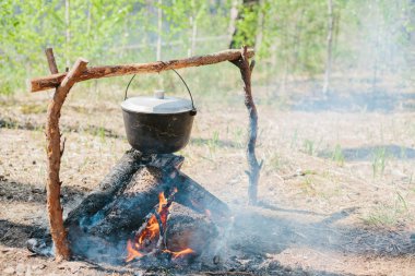 Ateşin yanında kamp. Yemek yemek bir yanıyor. Vahşi kavramı içine yolculuk.