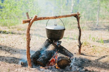 Ateşin yanında kamp. Yemek yemek bir yanıyor. Vahşi kavramı içine yolculuk.