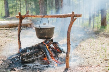 Ateşin yanında kamp. Yemek yemek bir yanıyor. Vahşi kavramı içine yolculuk.