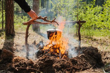 Ateşin yanında kamp. Yemek yemek bir yanıyor. Vahşi kavramı içine yolculuk.