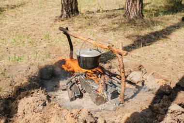 Ateşin yanında kamp. Yemek yemek bir yanıyor. Vahşi kavramı içine yolculuk.