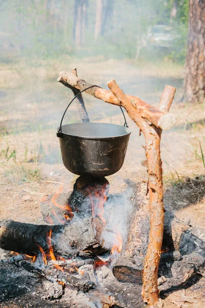 O incêndio perto do acampamento. Cozinhar comida numa fogueira. Viagem para o conceito selvagem . — Fotografia de Stock