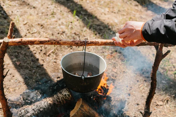 O incêndio perto do acampamento. Cozinhar comida numa fogueira. Viagem para o conceito selvagem . — Fotografia de Stock