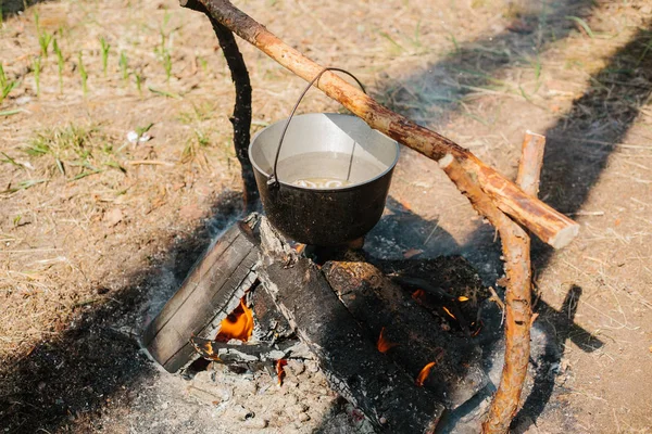 O incêndio perto do acampamento. Cozinhar comida numa fogueira. Viagem para o conceito selvagem . — Fotografia de Stock