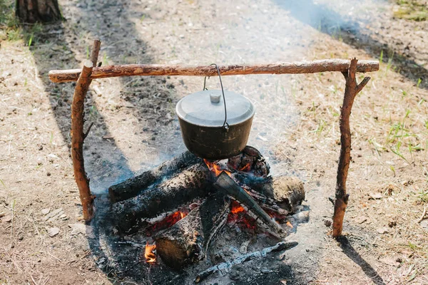 O incêndio perto do acampamento. Cozinhar comida numa fogueira. Viagem para o conceito selvagem . — Fotografia de Stock
