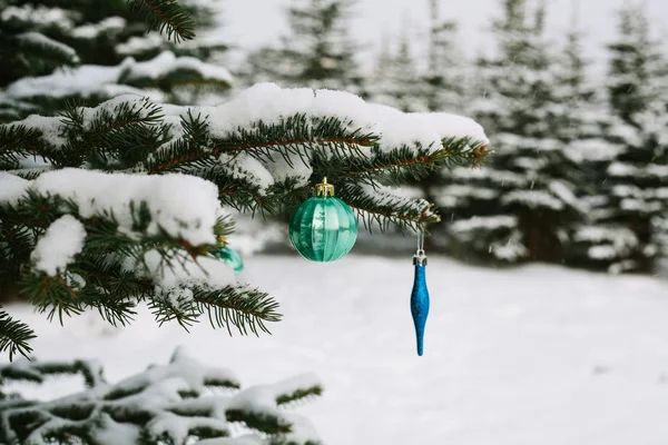 Decorations on the Christmas tree outdoors in a forest. Celebrating the New Year and holidays. — Stock Photo, Image
