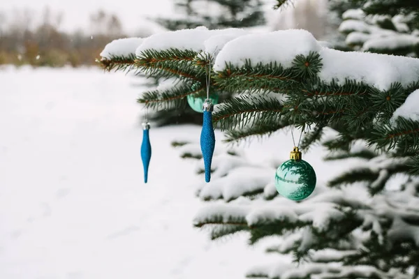 Decorations on the Christmas tree outdoors in a forest. Celebrating the New Year and holidays. — Stock Photo, Image