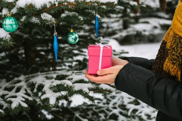 Girl holding a Christmas gift in a pink box — Stock Photo, Image