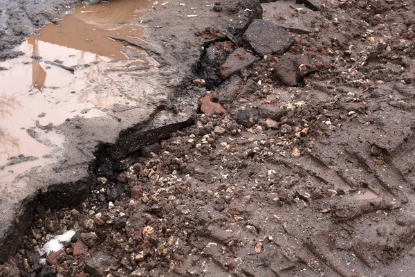 Сломанная дорога. грязь и вода на тротуаре . — стоковое фото