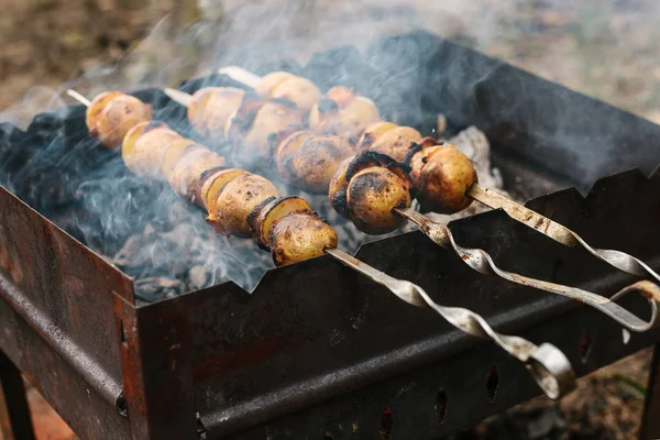 Pommes de terre frites avec du bacon sur les brochettes. Le concept de manger à l'extérieur le week-end . — Photo