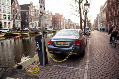 Amsterdam, Hollanda, 11 Aralık 2016 - güç kaynağı bir elektrikli araba takılı şarj ediliyor.