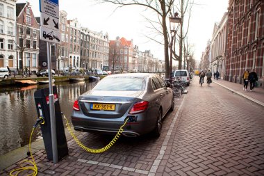Amsterdam, Hollanda, 11 Aralık 2016 - güç kaynağı bir elektrikli araba takılı şarj ediliyor.