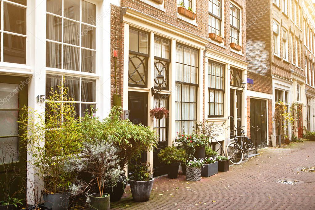 Beautiful street with houses decorated with plants in the capital of the Netherlands - Amsterdam. European-style housing.