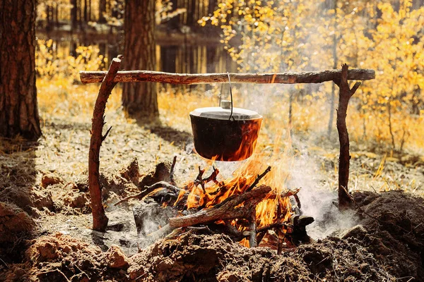 De brand in de buurt van het kamp. Koken voedsel op vuur. Reis naar het wild concept. — Stockfoto