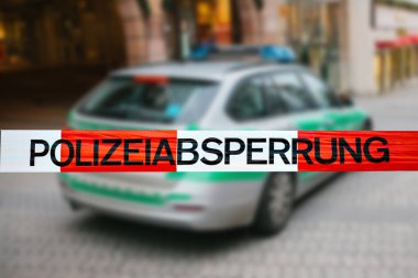 Olay yerinde polis teyp. Polis teyp, bir polis arabasının arka plan bulanık üzerinde odaklanmaktadır. Alman polisi.